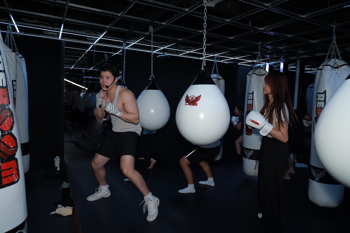 格鬥館裡多位參加者同時對著沙包出拳，場面熱絡