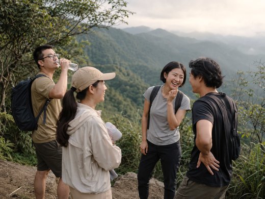 一群人在山稜線的展望點休息喝水、開心聊天